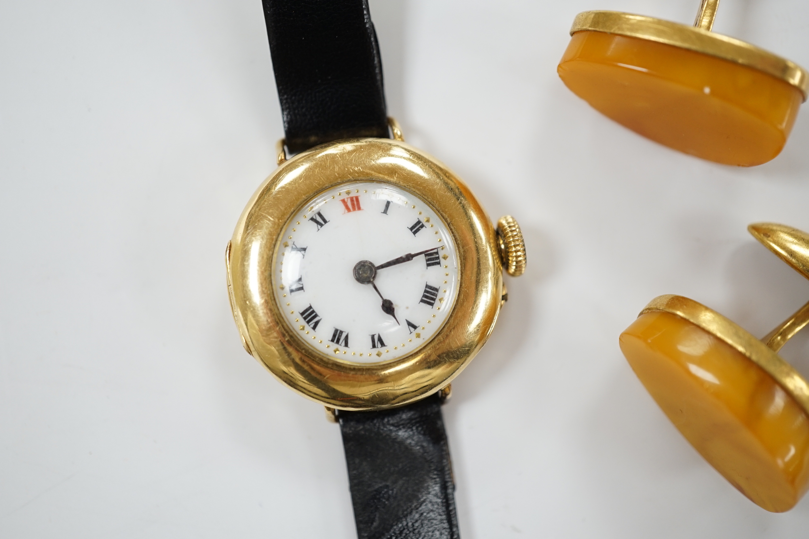 A lady's George V 18ct gold manual wind wrist watch, on later associated leather strap, case hallmarked for London, 1916, together with a pair of amber set gold plated cufflinks.
